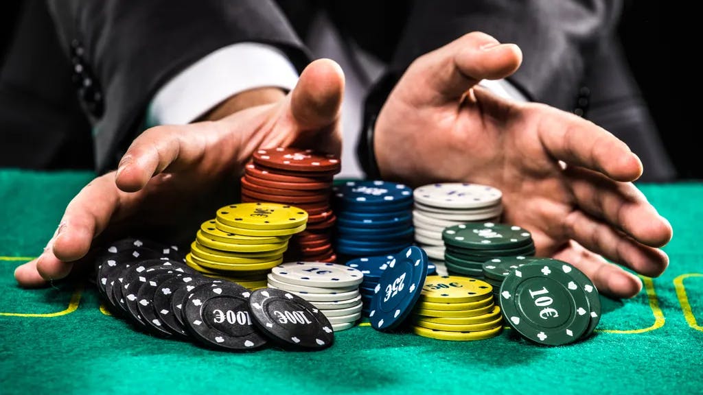 Casino, Glücksspiel, Poker, Menschen und Unterhaltung Konzept - Nahaufnahme des Poker-Spielers mit Chips am grünen Casino-Tisch
